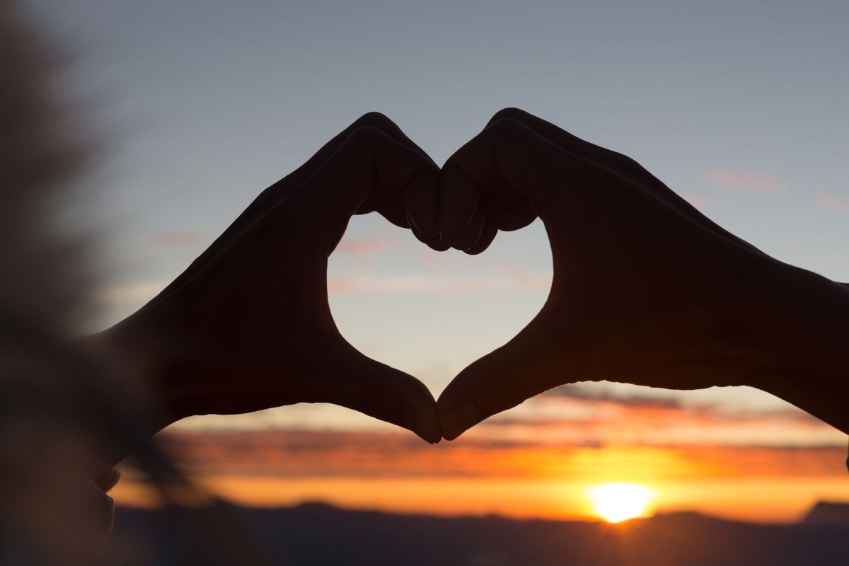 Woman making heart shape during sun rise, God is love concept, Heart shape, Mountain tourism, Symbol of love, The manifestation of love, Expression of feelings. Love of nature, 