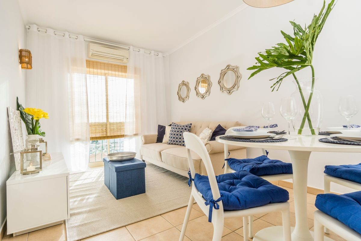 Living room with a dining table in modern, luxury apartment illuminated by afternoon sun